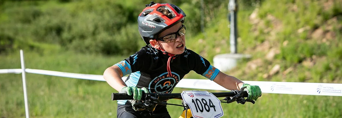 Junior racer cycling uphill in a mountain bike race.