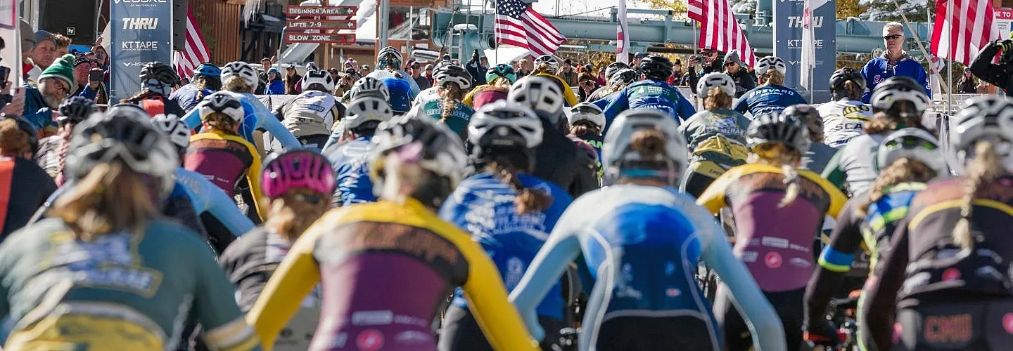 Collegiate race start line behind the riders as they start biking.