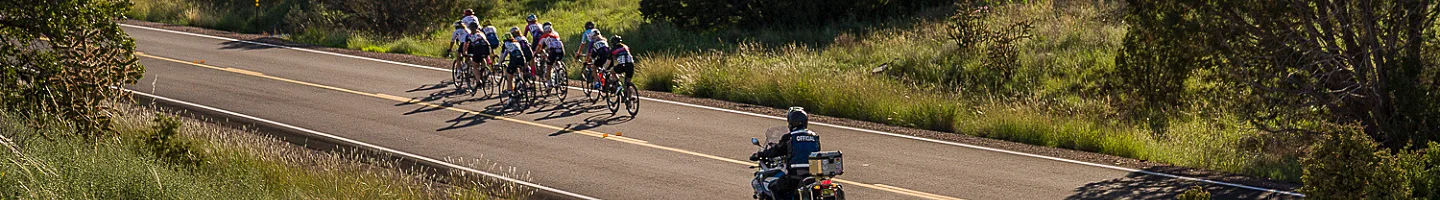 A man on a motorcycle following a group of bike racers