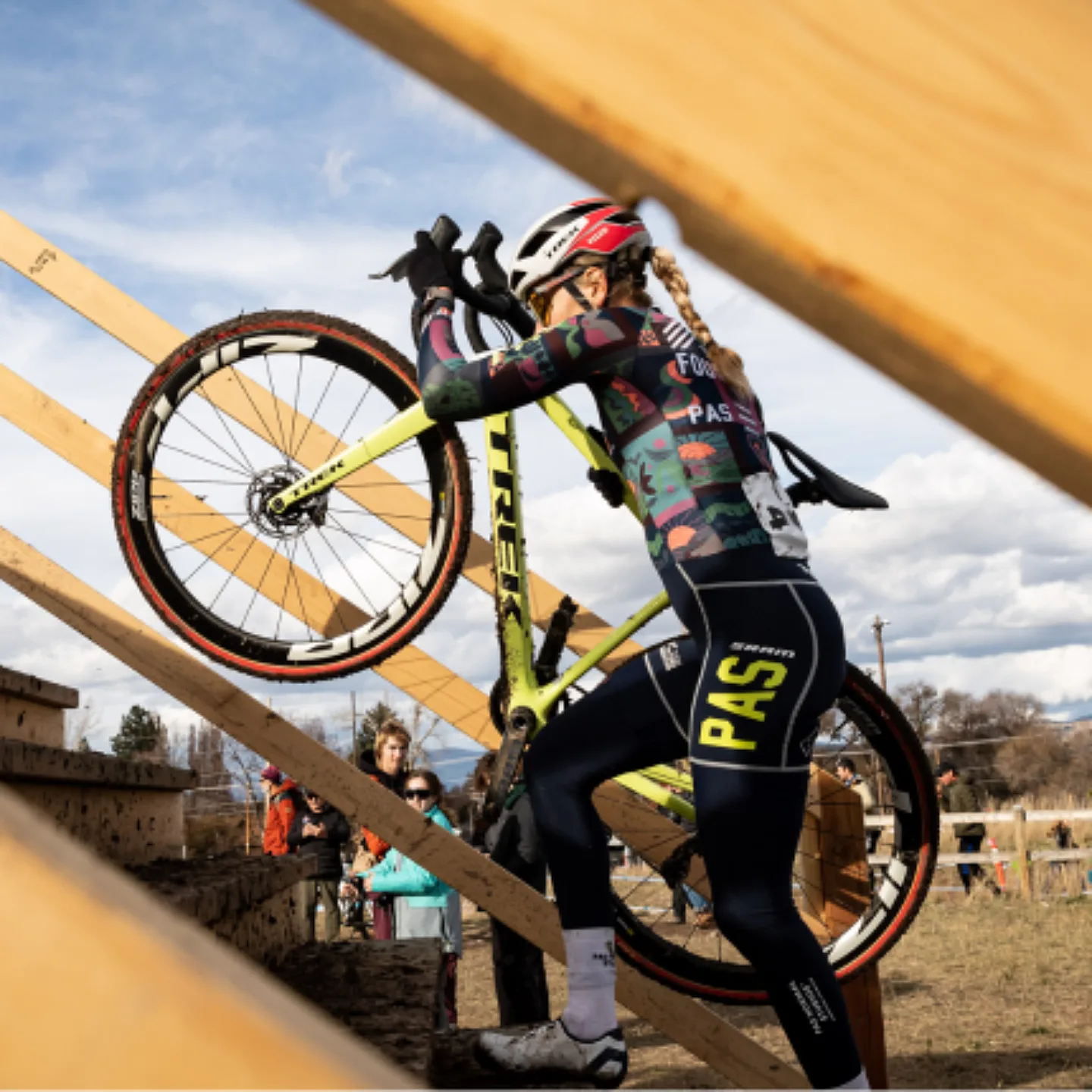 A cyclocross racer climbing the stair section of a race course with their bike