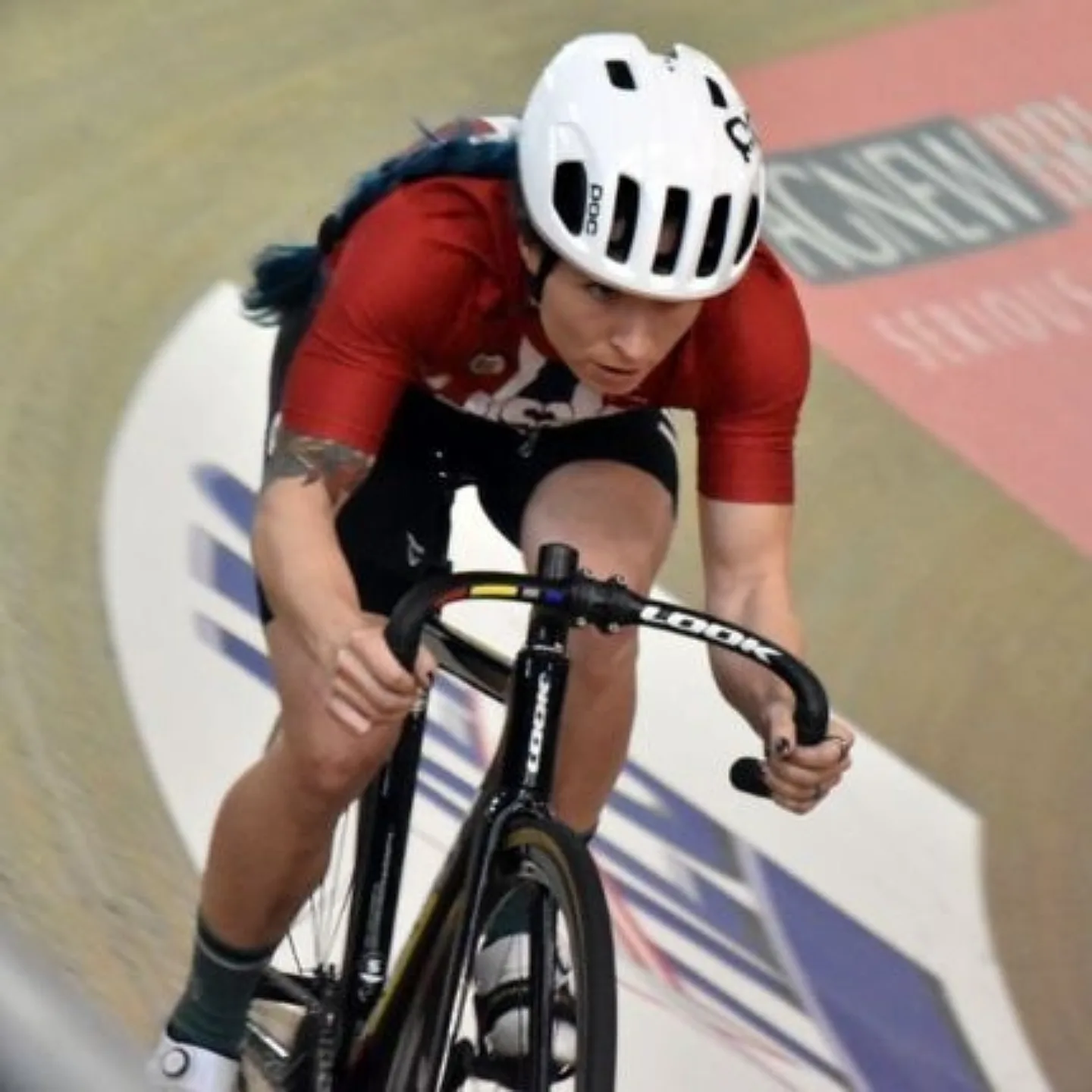 Woman biking in velodrome.