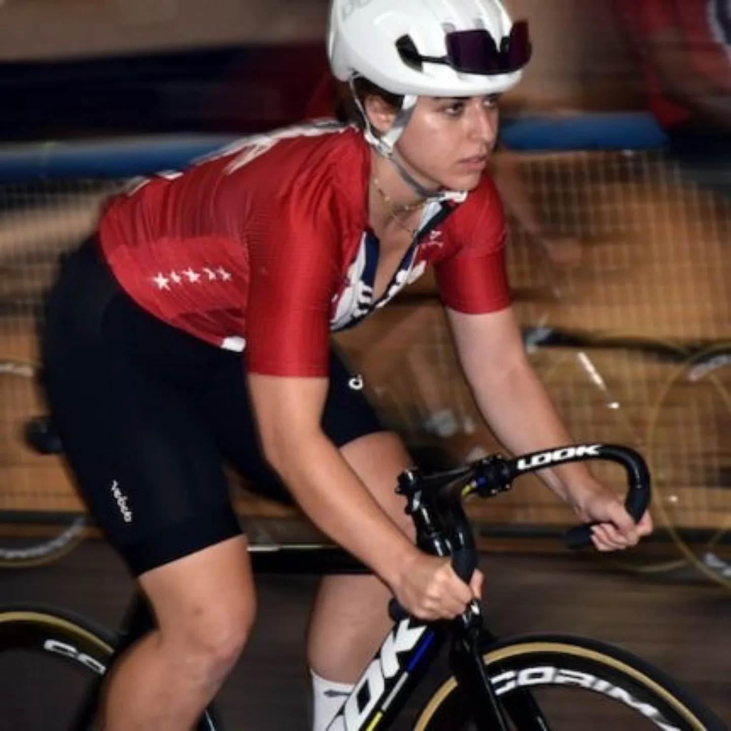 Woman biking in velodrome.