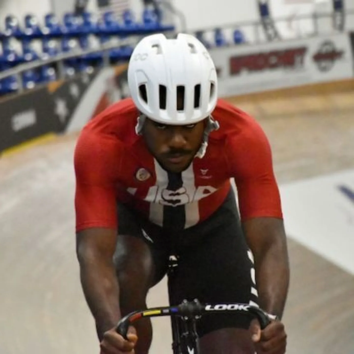 Man biking in velodrome.