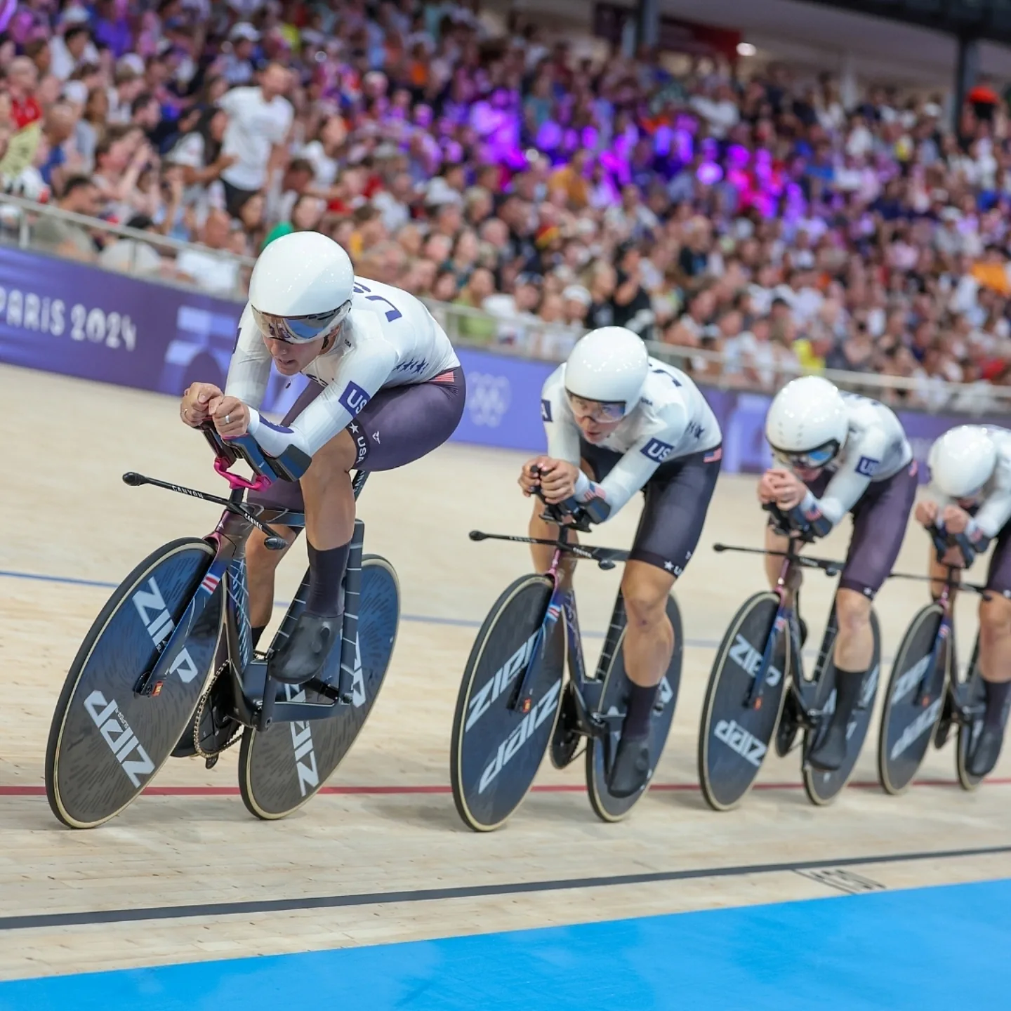 Team USA track pursuit team racing in velodrome.