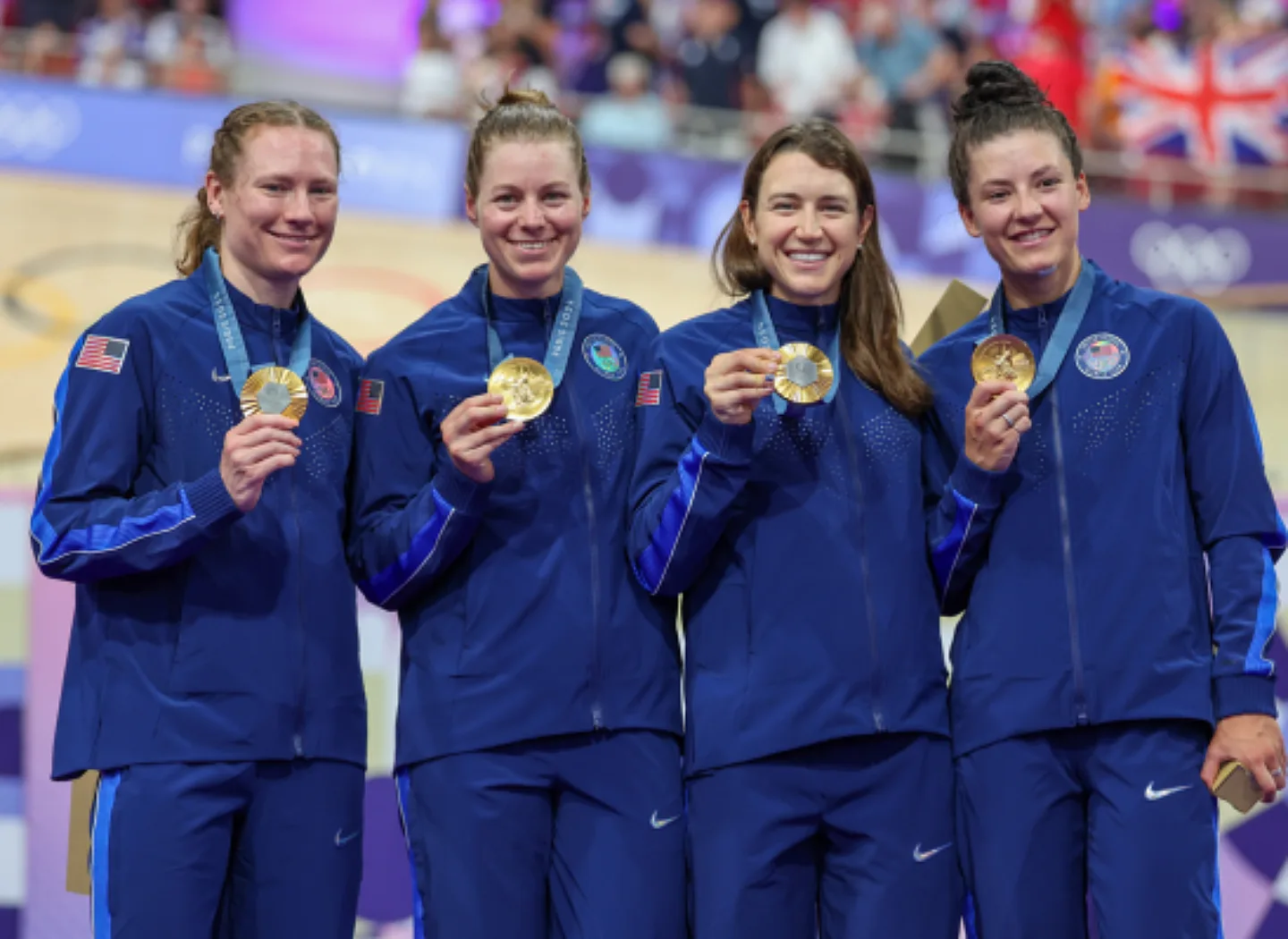 Women's Team Pursuit posing and holding up their medals.