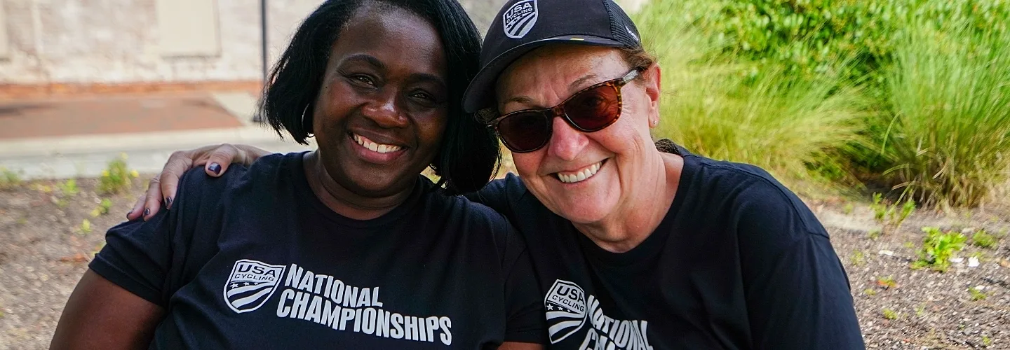 Two women in National Championship shirts hugging and smiling.