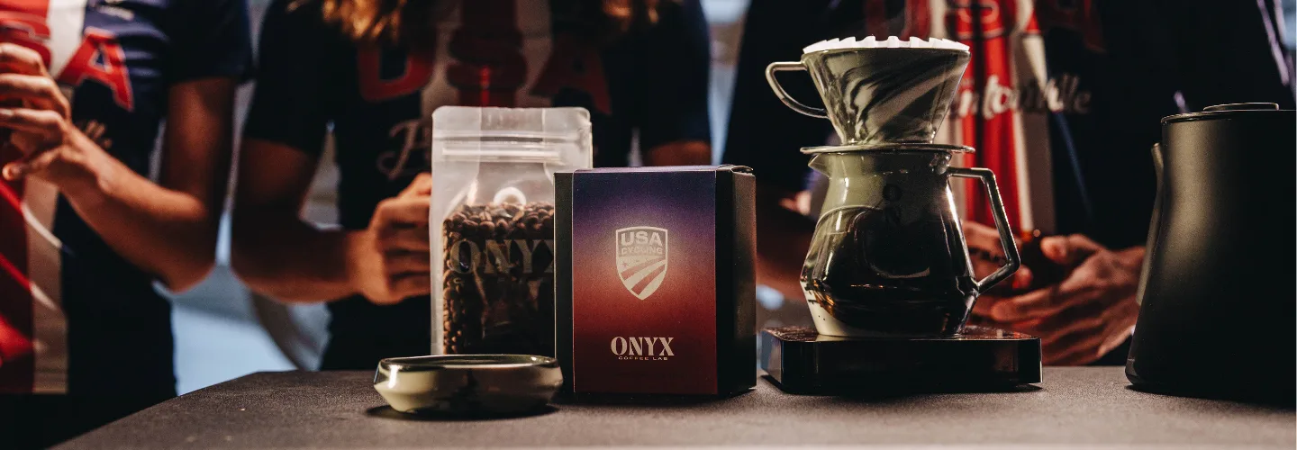 A bag of ONYX coffee beans sitting on a table next to a coffee maker