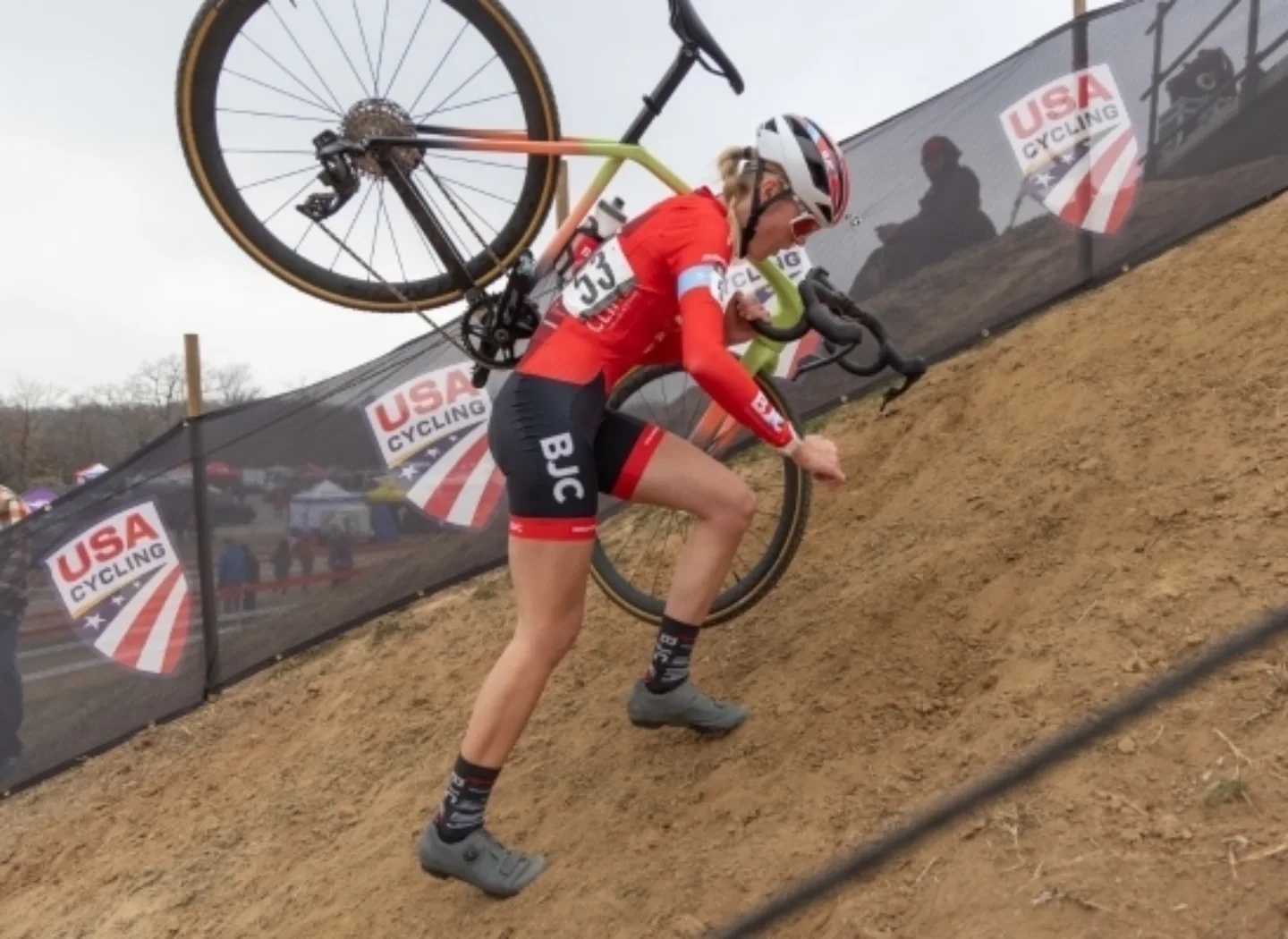 Cyclist carrying bike up a hill