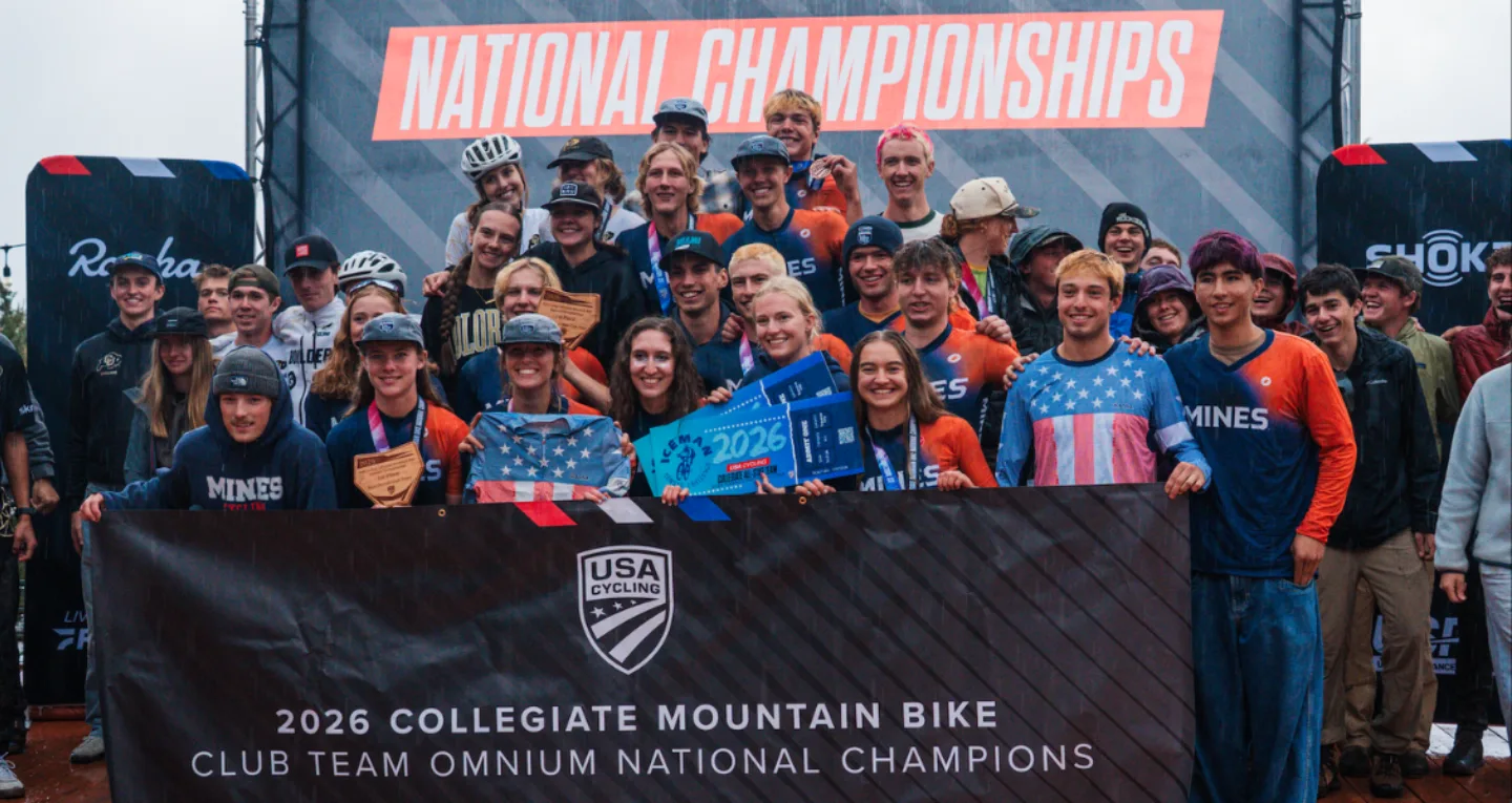 Group of cyclists posing behind a Club Team Omnium Champions podium banner at the 2026 Collegiate Mountain Bike National Championships event.